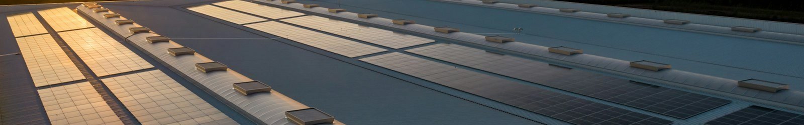 Telhado de edifício comercial com módulos fotovoltaicos instalados sobre estrutura metálica